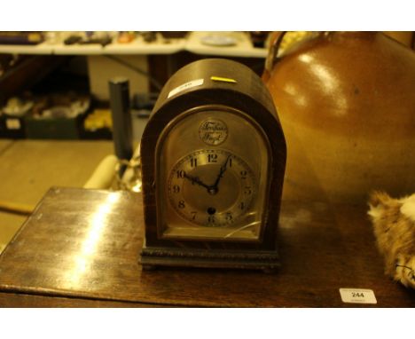 A Tempus Fugit oak cased single hole mantel clock