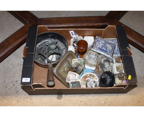 A box containing antique blue and white tiles, cutlery, a brass chamber stick etc. 