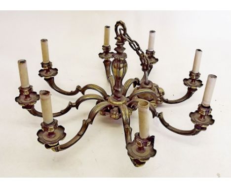 A large heavy brass eight branch chandelier light fitting 