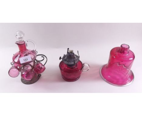 A cranberry glass decanter and four liquor glasses, a cranberry small glass oil lamp and a cranberry glass shade