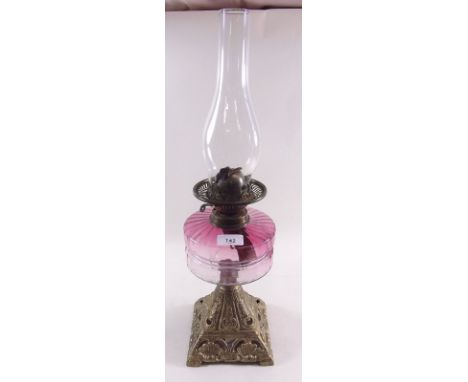 A Victorian gilt metal oil lamp with cranberry glass reservoir  