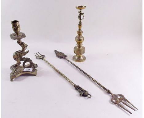 A brass Welsh dragon candlestick, two toasting forks and another candlestick