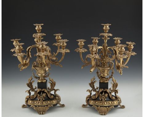 A VICTORIAN STYLE EBONISED AND GILT THREE PIECE CLOCK GARNITURE, comprising of a mantle clock, surmounted with a classical ur