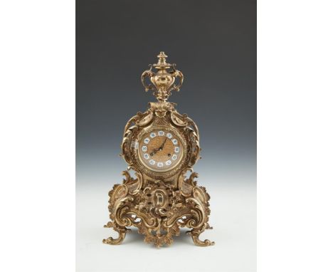 A FRENCH CAST BRASS MANTLE CLOCK, 20th century, surmounted by an urn over a gilt metal and enamel dial with Roman numerals, d