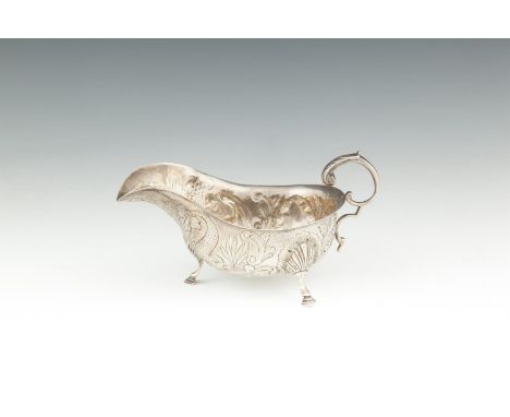 AN IRISH PROVINCIAL SILVER SAUCE BOAT, Cork 1935, mark of William Egan, of helmet form, with applied 's' scroll handle, the b
