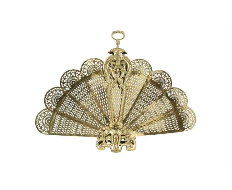 A FRENCH BRASS PEACOCK TAIL FAN SHAPED FIREGUARD, 19th century, fitted with nine pierced brass panels within a foliate cast f