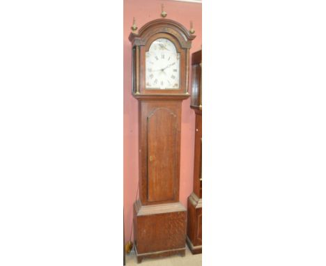 An early 19th century oak longcase clock with domed hood and hand-painted enamel dial set with Roman numerals, flanked by two