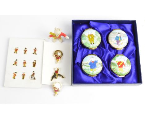 A boxed set of Royal Doulton enamel Rupert characters, a group of enamelled lapel pins, three brooches and a plastic figure o