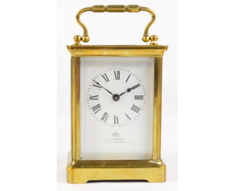 A late 19th century French brass cased carriage clock with swing loop handle above white enamel dial set with Roman numerals 