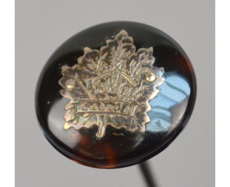 A sterling silver circular hat pin, the faux tortoiseshell disc head set with a silver maple leaf engraved with a crown inscr