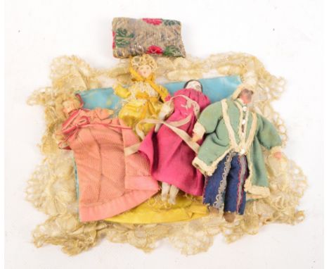 A small collection of 19th century dolls including three cloth dolls, the female with long gowns covering the lack of legs, t