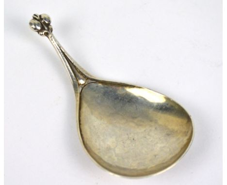 An Edward VII hallmarked silver Arts and Crafts "Cymric" caddy spoon with hammered fig shaped bowl and stylised finial, Liber