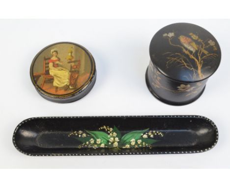 A mid 19th century circular hand painted lacquered snuff box depicting a woman seated in a chair beside a spinning wheel, dia