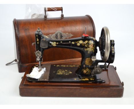 A Singer MFG Co NY hand sewing machine, decorated with floral transfers, including sewing instruction leaflets, spools, etc, 