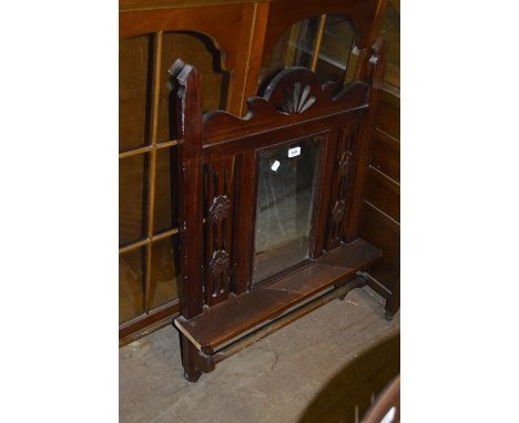 A mahogany wall mirror with central bevelled plate and shelf above towel rail.