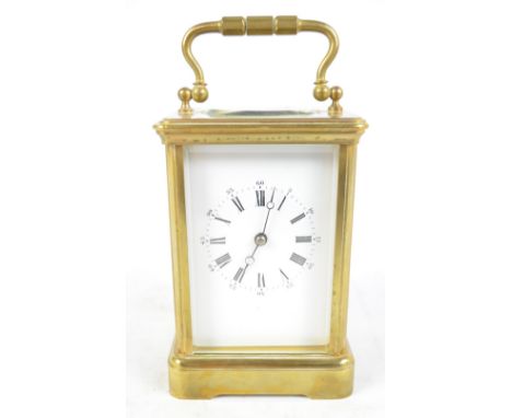 An early 20th century brass carriage clock with bevelled glasses, the white enamel dial set with Roman numerals and second in