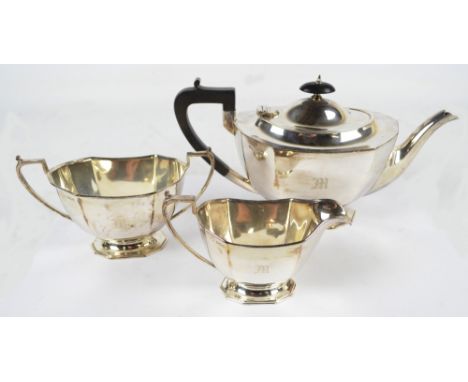 A George V hallmarked silver three piece tea service comprising teapot of oval form with canted corners, raised on shaped bas