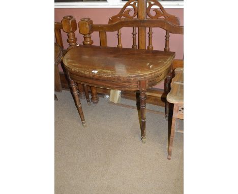 A late George III mahogany demi-lune card table raised on ring turned tapering legs, width 92cm, af.