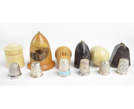 A collection of six silver thimbles in cases, comprising a domed Mauchline Ware case, containing a flower head decorated thim