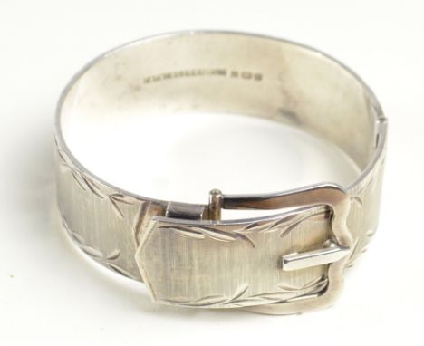 A hallmarked silver snap bangle modelled as a belt with bright cut decoration, patent no.960949, diameter approx 6cm.