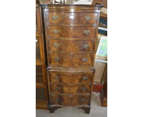 A reproduction mahogany serpentine outline chest on chest of small proportions, with central brushing slide and bracket feet,