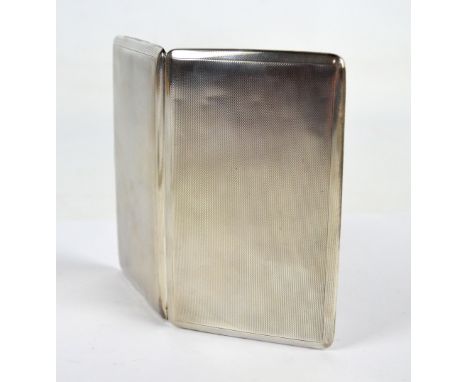 A George VI hallmarked silver cigarette case of rectangular form with overall engine turned decoration, centred with a vacant