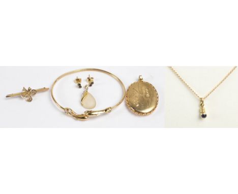 A group of 9ct yellow gold jewellery comprising an oval locket pendant engraved with a butterfly, a dolphin decorated bangle,
