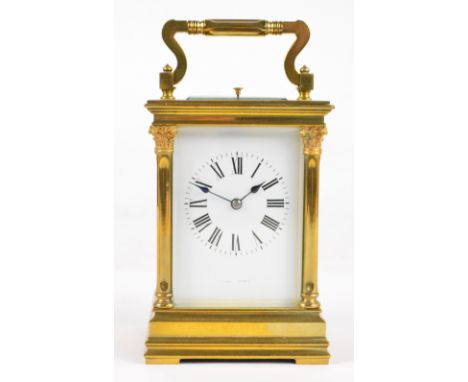 A large late 19th century French brass repeating carriage clock with swing loop handle above rectangular white enamel dial se