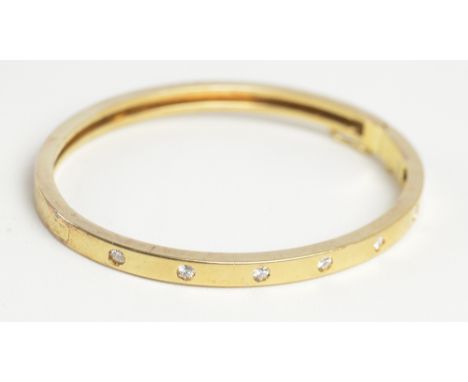 An 18ct yellow gold diamond set hinged bangle, the platform set with seven small diamonds, 6.3 x 5.2 external dimensions, app