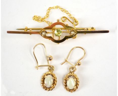 An Edwardian 9ct yellow gold bar brooch with lobed central sections set with peridot flanked by two seed cultured pearls, len