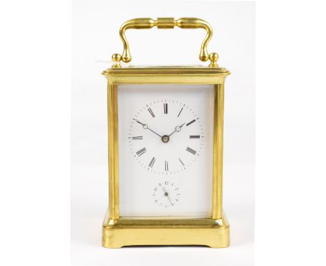 A large late 19th century French brass cased carriage clock with swing loop handle above white enamel dial set with Roman num