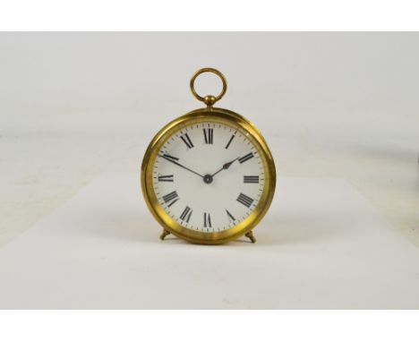 An early 20th century brass cased circular drum clock with ring loop handle above circular white enamel dial set with Roman n