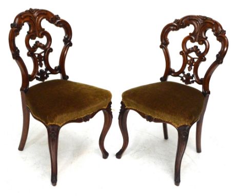 A Victorian eight piece walnut salon suite, comprising six floral carved pierced back dining chairs with serpentine stuffover