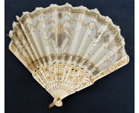 An English late 19th century fontange or balloon shaped quizzing fan with gilt heightened pierced bone guards and matching st