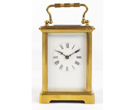 A c.1900 French brass cased carriage clock with swing loop handle above white enamel dial set with Roman numerals, with unnum