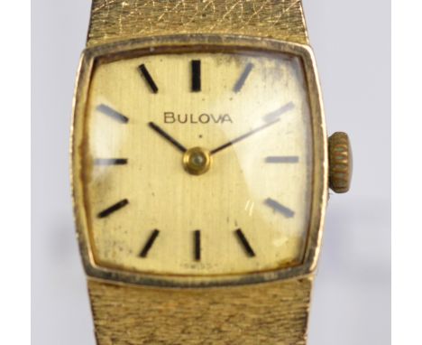 BULOVA; a 9ct yellow gold cased manual wind lady's wristwatch, the tonneau shaped dial set with baton numerals, on integrated