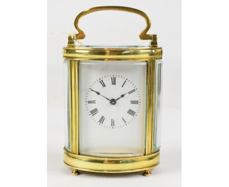 A rare late 19th century French brass oval petit zero lever carriage clock with swing loop handle above rectangular white ena