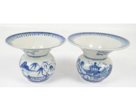 A pair of 19th century Chinese porcelain averted vases with squat globular bodies, painted in underglaze blue with architectu