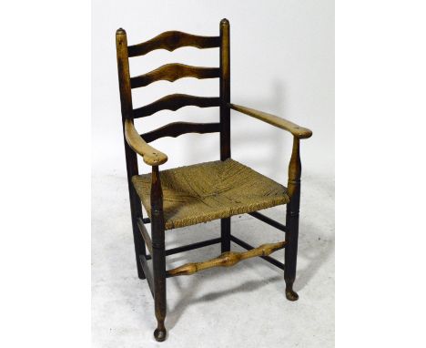 A 19th century ash and elm low ladder back elbow chair with swept broad arms, string seat and turned legs united by stretcher
