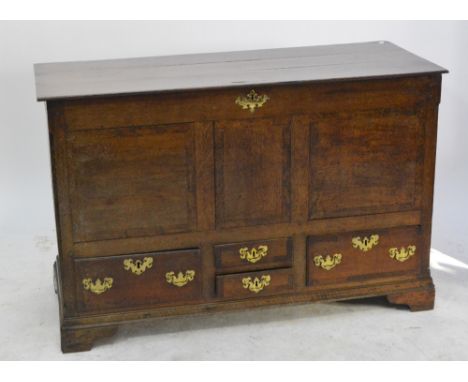 A George III oak mule chest, the hinged lid above four drawers, with brass handles and escutcheons over bracket feet, height 