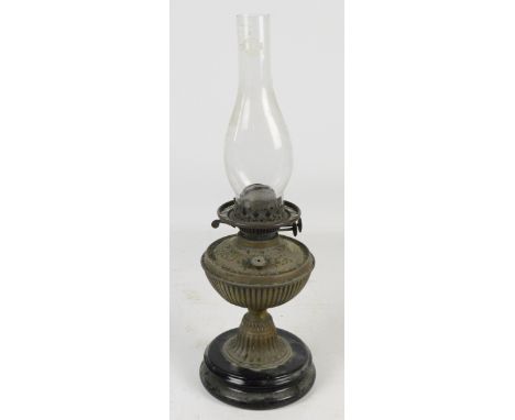 A Victorian brass oil lamp on black glazed ceramic base with funnel.