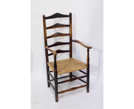 An early 19th century ash and elm ladder back elbow chair with swept arms, string seat, turned uprights and double row of tur