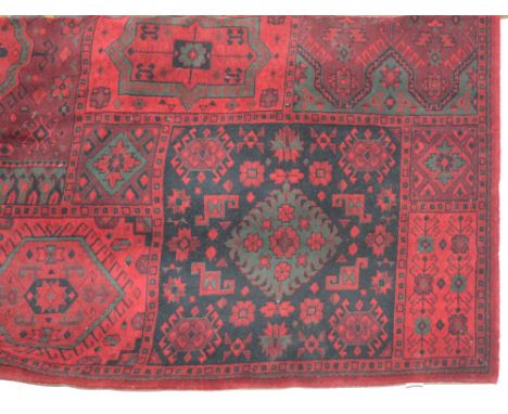 A large red ground Turkish design carpet with allover device set panels and stylised border.