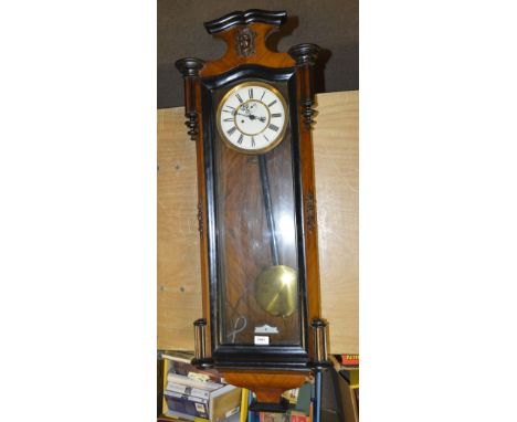 A 19th century Vienna style walnut and ebonised detailed eight day wall clock, the shaped mask decorated pediment above circu