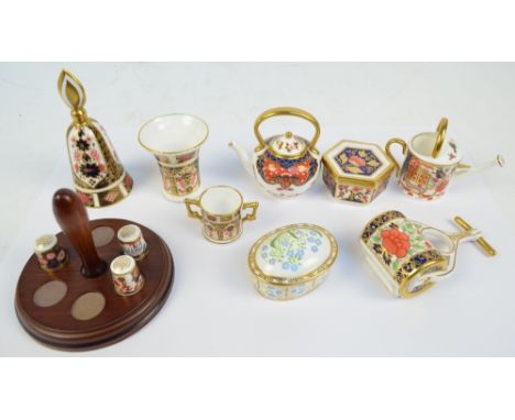 A group of Royal Crown Derby including a garden roller, trumpet vase, bell, watering can, kettle, twin handled loving cup, he