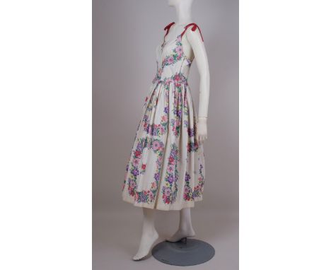A 1950'S COTTON FLORAL DRESS WITH BOLERO JACKET A pretty floral cotton dress with rose pink bolero jacket and sash, side meta