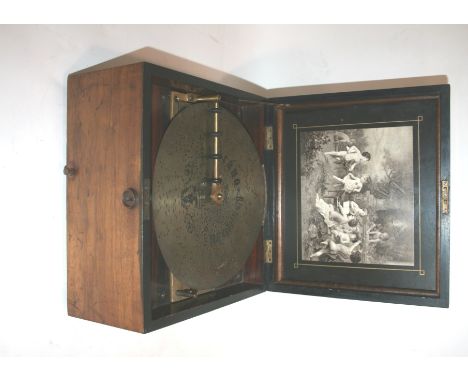 POLYPHON MUSICAL BOX a disc playing polyphon in a walnut case, with a number of discs and winding handle. Case 34 by 30cms.