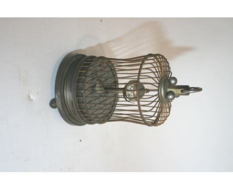 AUTOMATON CLOCK with a clockwork mechanism operating a moving bird in a cage, with numerals around a central pillar. 13cms hi