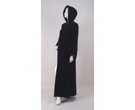 A VINTAGE BLACK VELVET COAT/CLOAK WITH HOOD. This heavy cotton velvet coat is fastened at the neck with a large button (broke