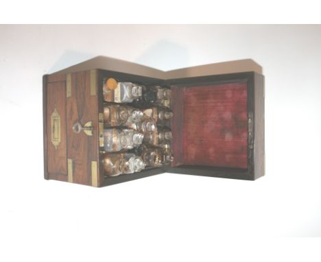 19THC TRAVELLING MEDICAL CABINET a rosewood cabinet with brass recessed handles and fittings. The interior with a qty of medi